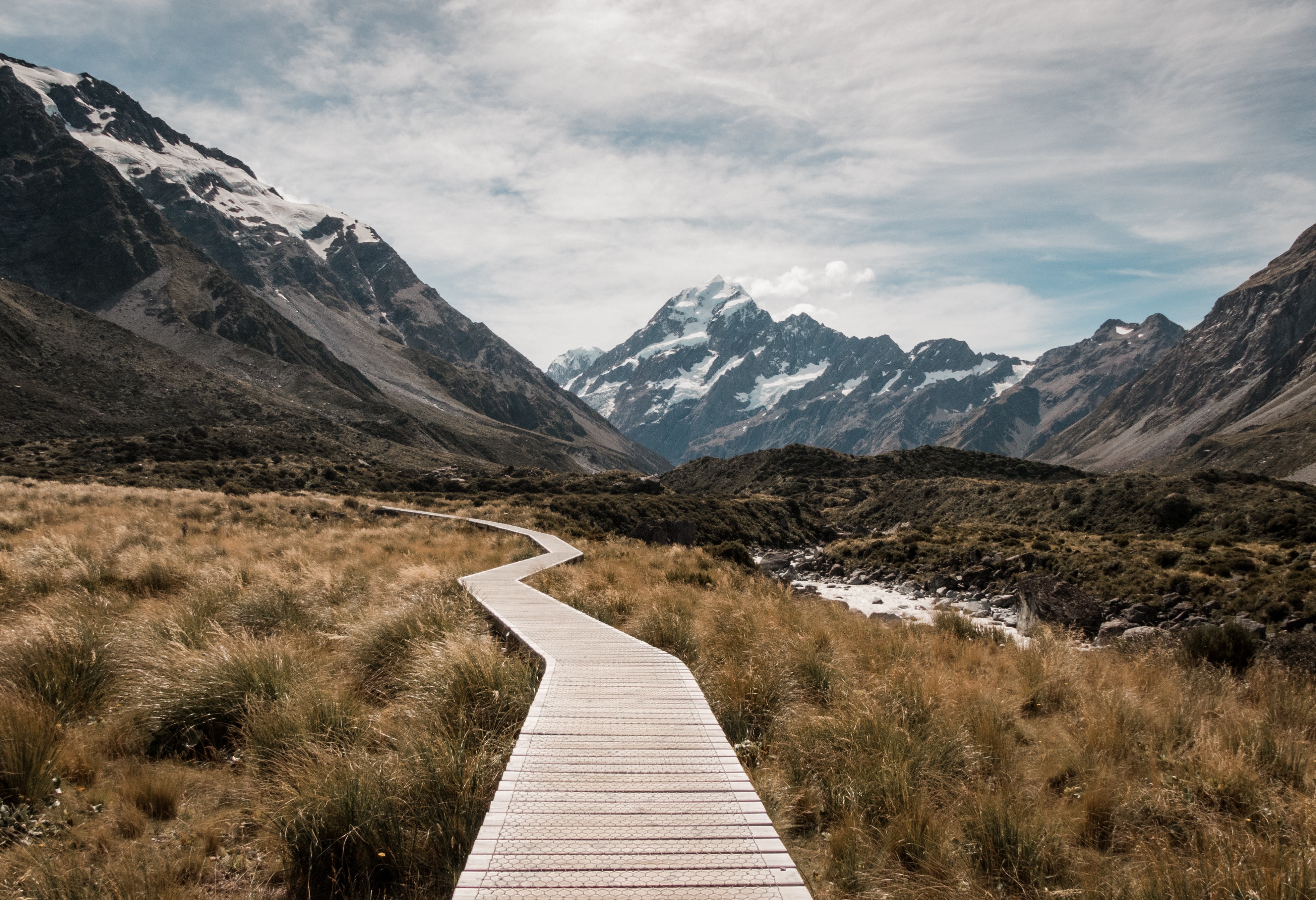 Photo of mountain landscape with a winding path through the grass