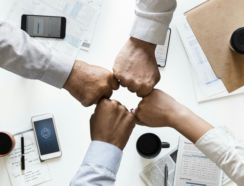 Photo of team hands together over office table